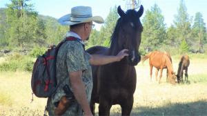 William E. Simpson II is greeted by a wild mountain stallion in the Soda Mountain Wilderness area.