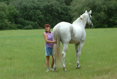 Me holding the back leg of Khan while he was in my farrier's field. Lots of trust there! Big horse, lol.